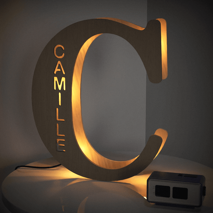 Enchanted Woodland Alphabet Lamp in shape of letter C with name Camille illuminated, adding charm and warmth to room decor.